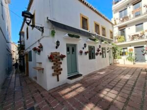 Traditional Marbella Old Town street with white houses flowers and tiled pavement