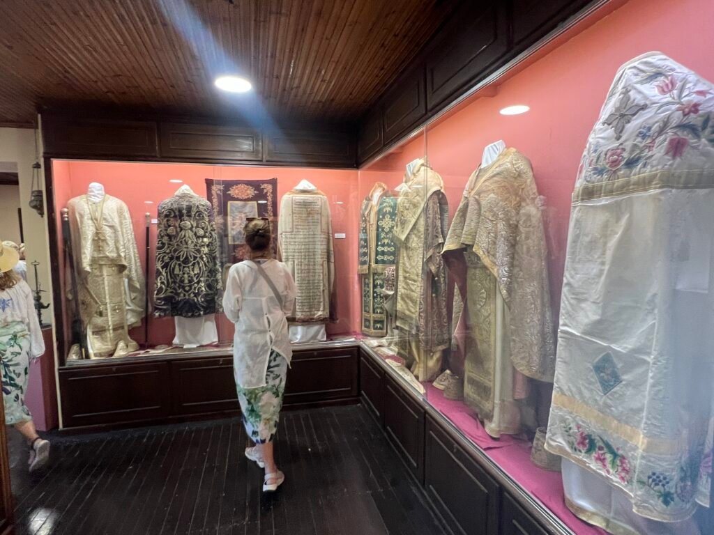 Woman viewing embroidered religious vestments in the Paleokastritsa Monastery museum