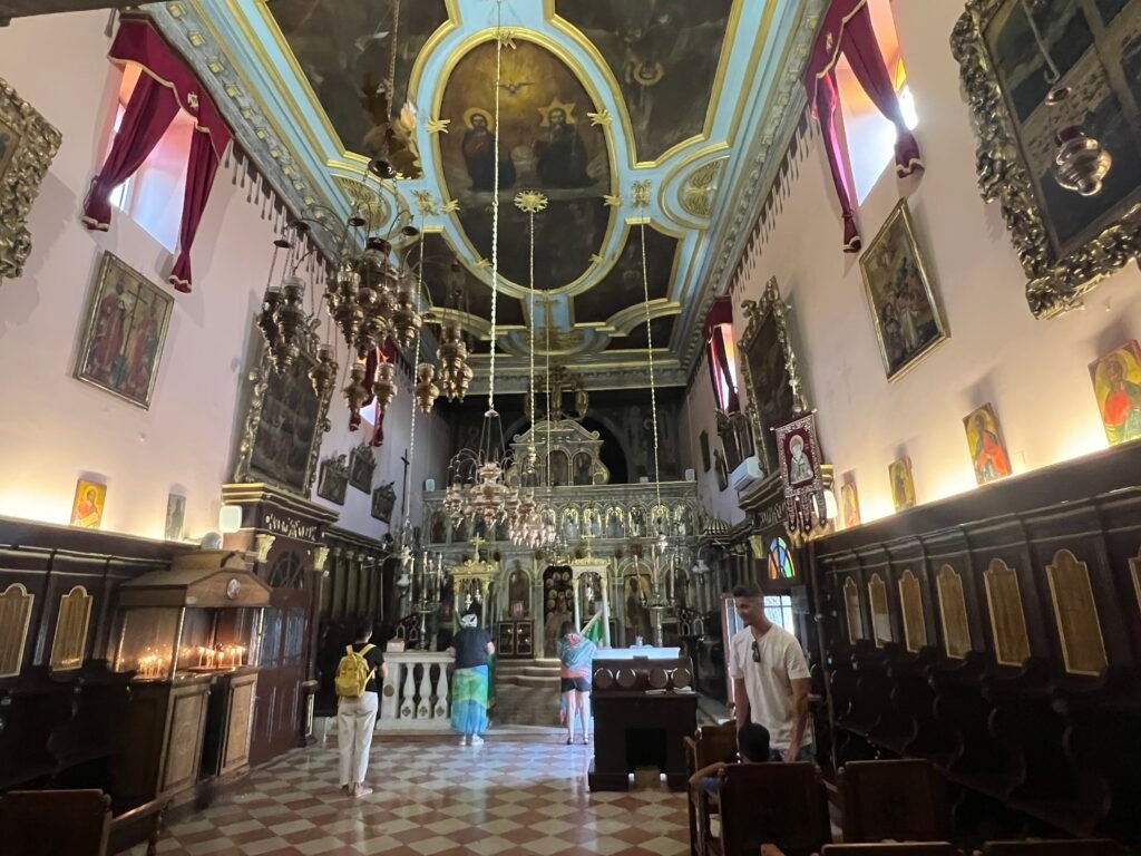 Interior of Paleokastritsa Monastery church with painted ceiling and hanging chandeliers