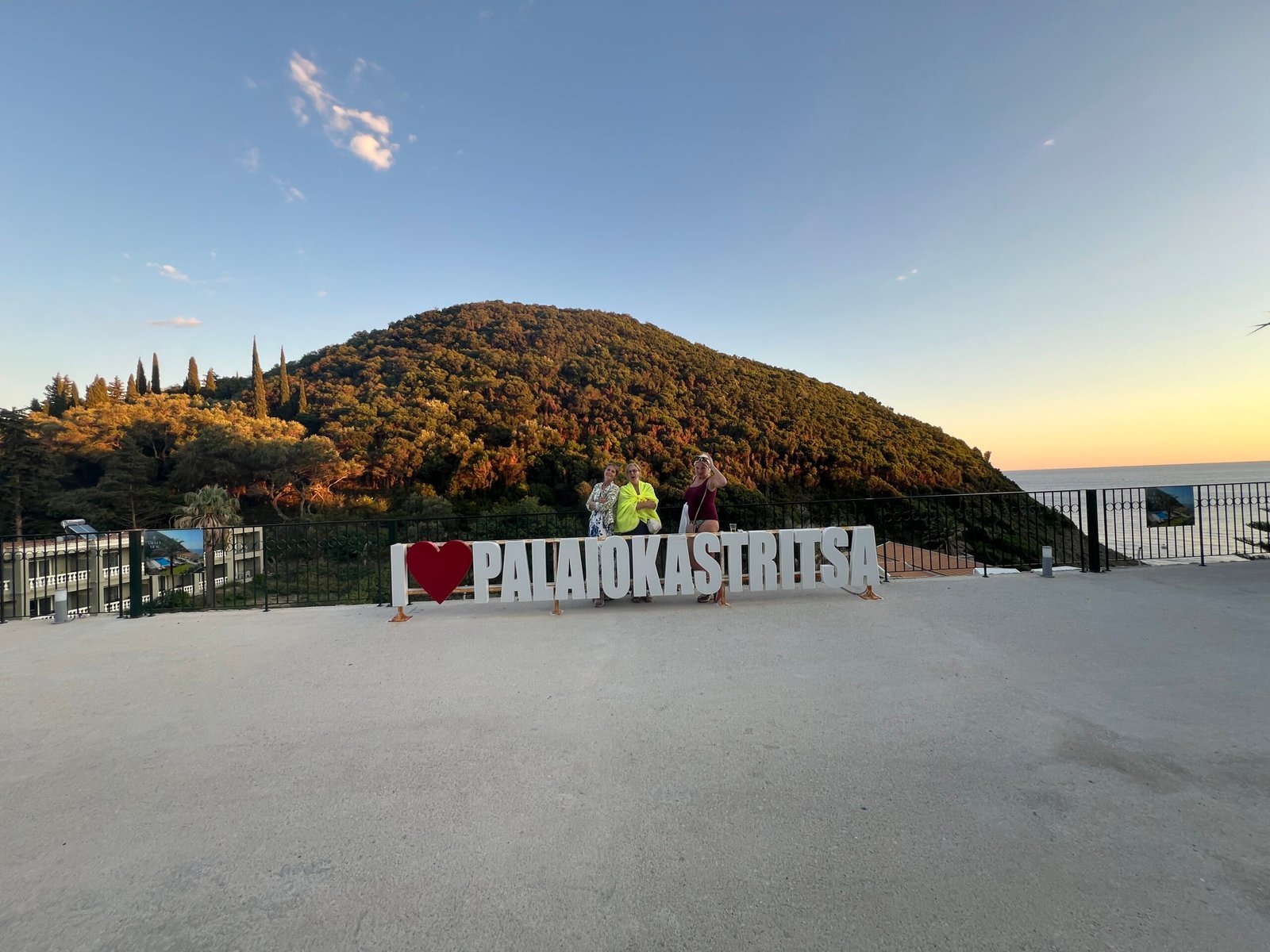Visitors beside the I love Palaiokastritsa sign near La Grotta