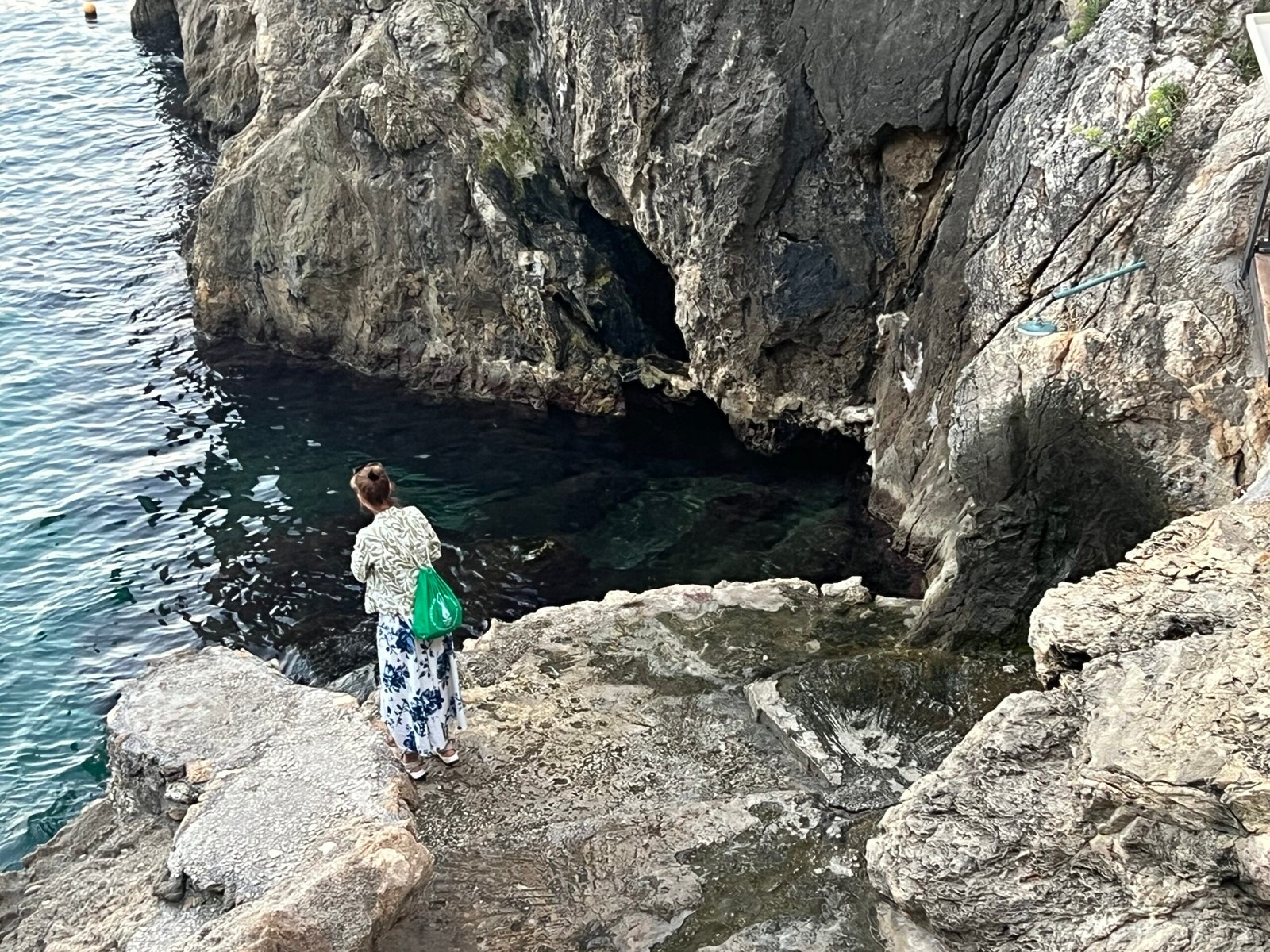 Rock face and clear water below the steps at La Grotta