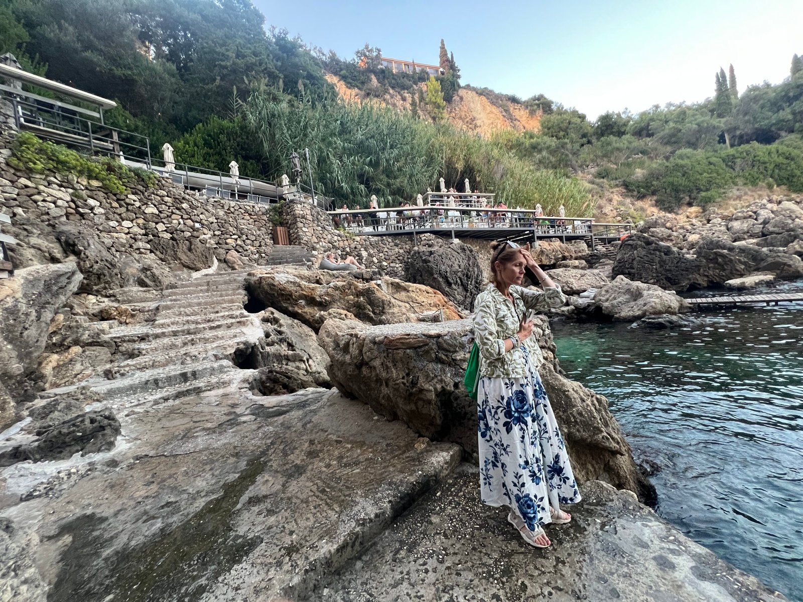 Visitor on the rocks beside the sea at La Grotta in Paleokastritsa