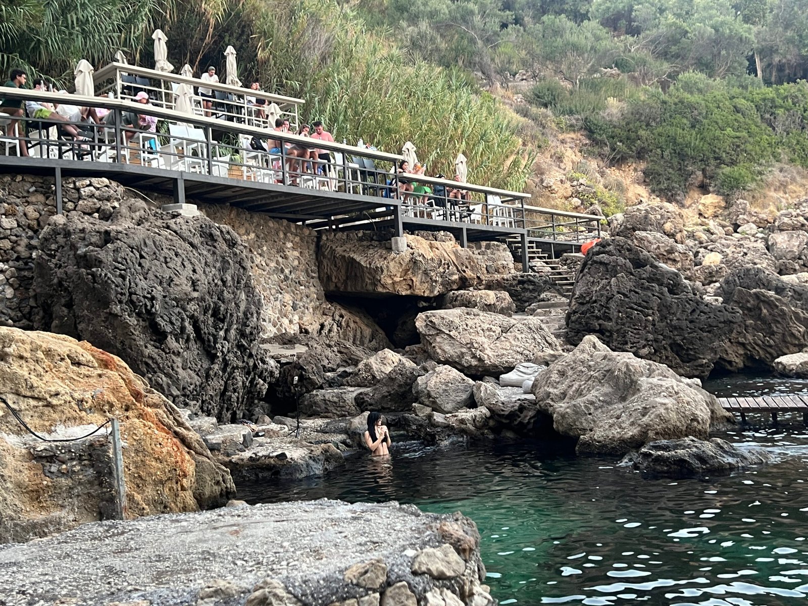 La Grotta bar terrace above swimmers and turquoise water