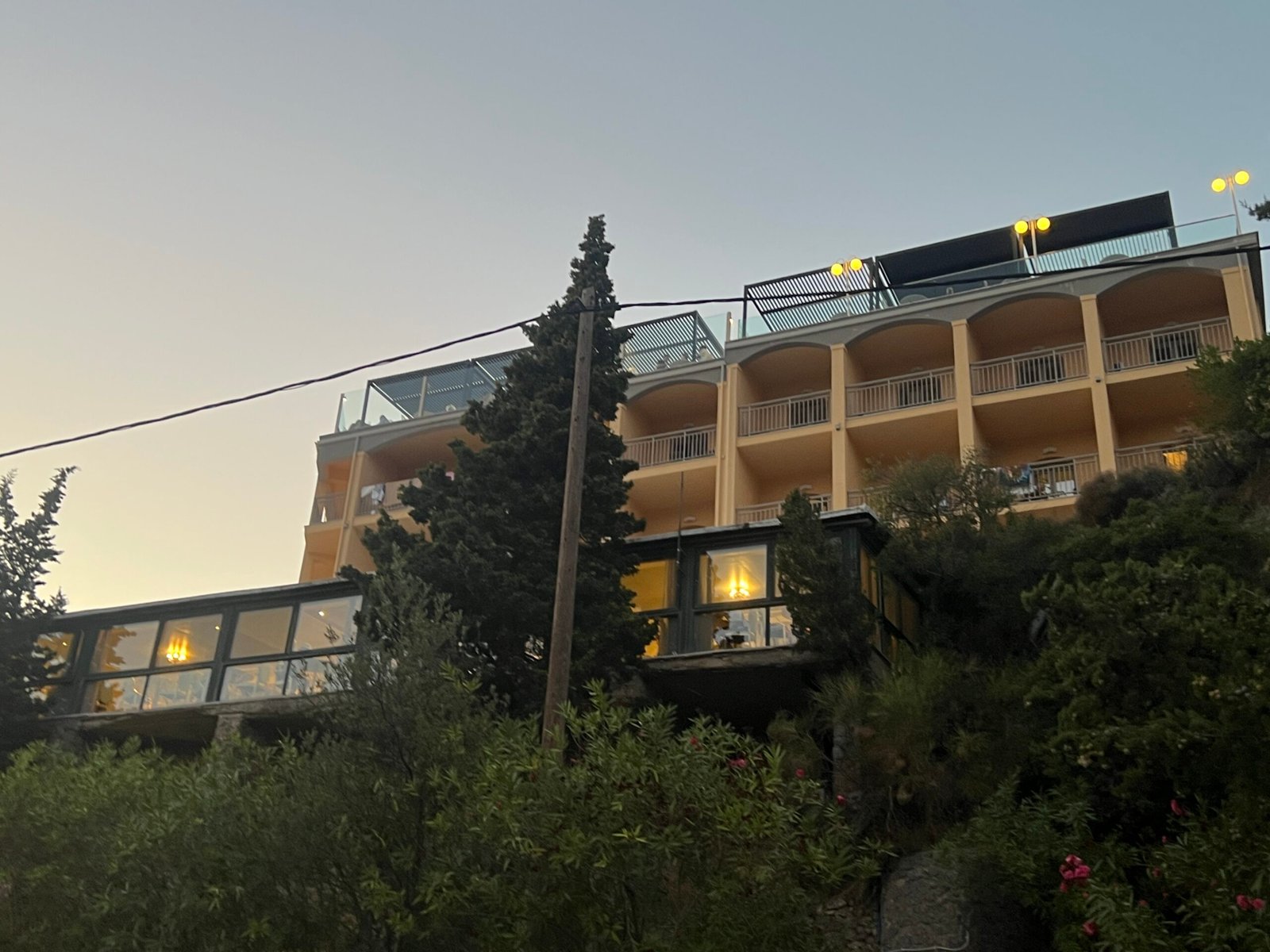 Hillside hotel building above the road near La Grotta