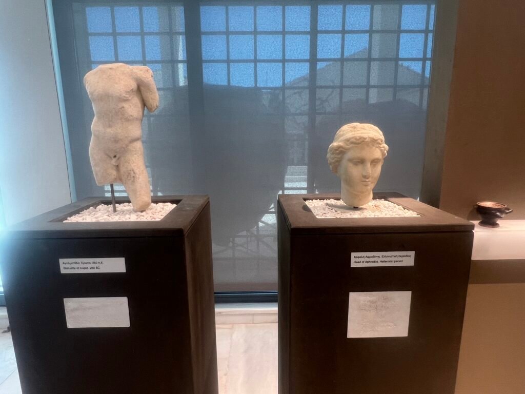A statuette of Eros (Cupid), labelled 250 BC, beside a Hellenistic head of Aphrodite.