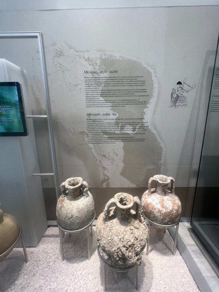Large pottery vessels beside the display explaining pottery production.