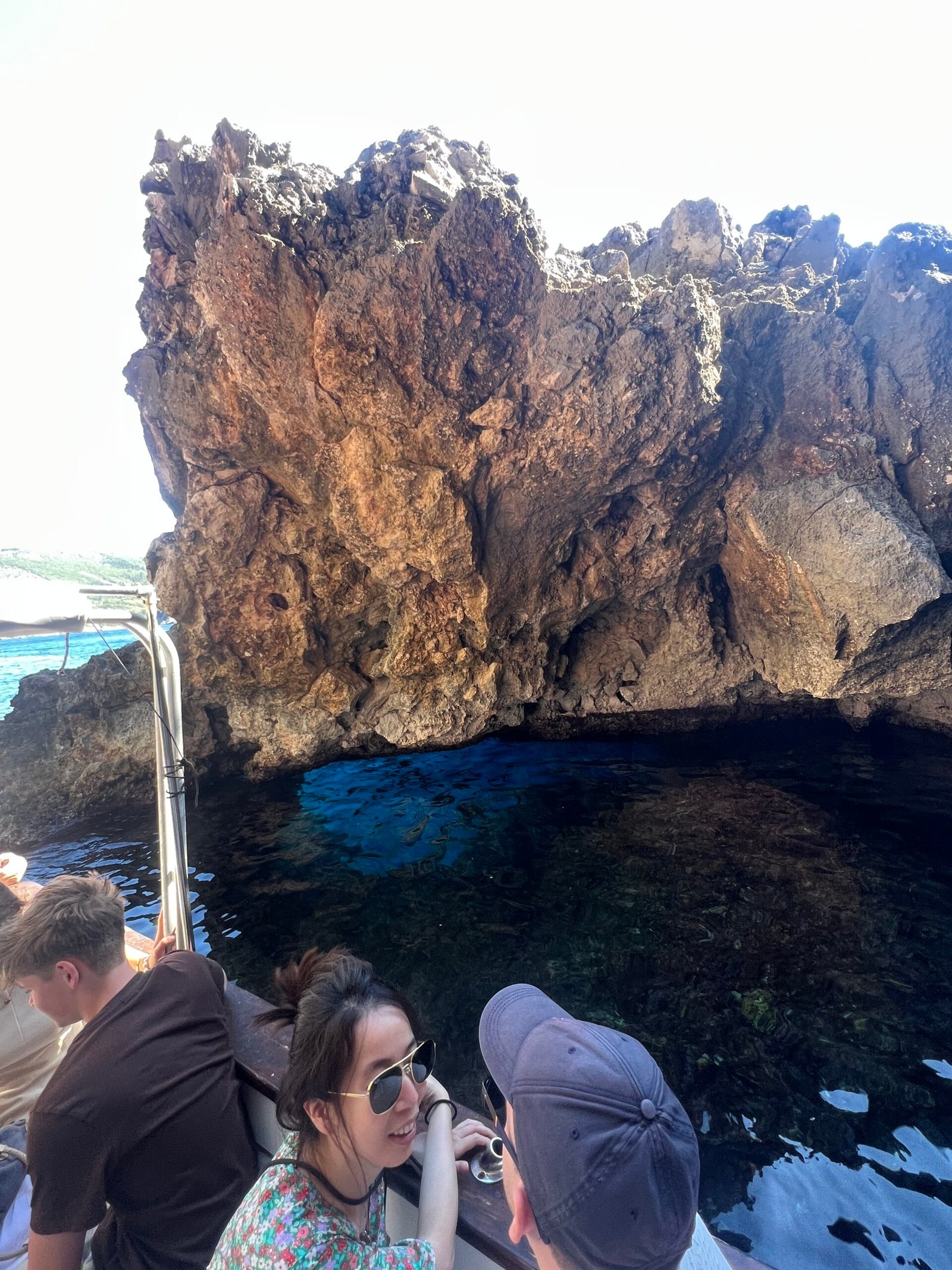 Passengers beside golden sea cliffs on the Paleokastritsa cave route