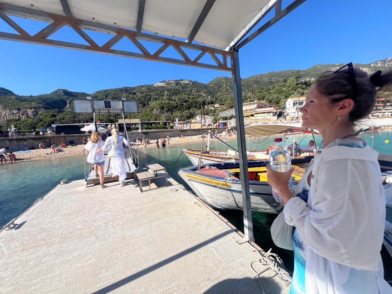 Visitor beside the covered boats at the Paleokastritsa departure point