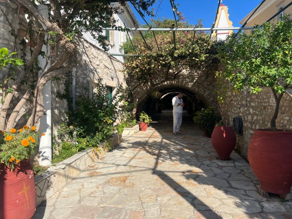 Visitor walking along the planted stone approach to Paleokastritsa Monastery