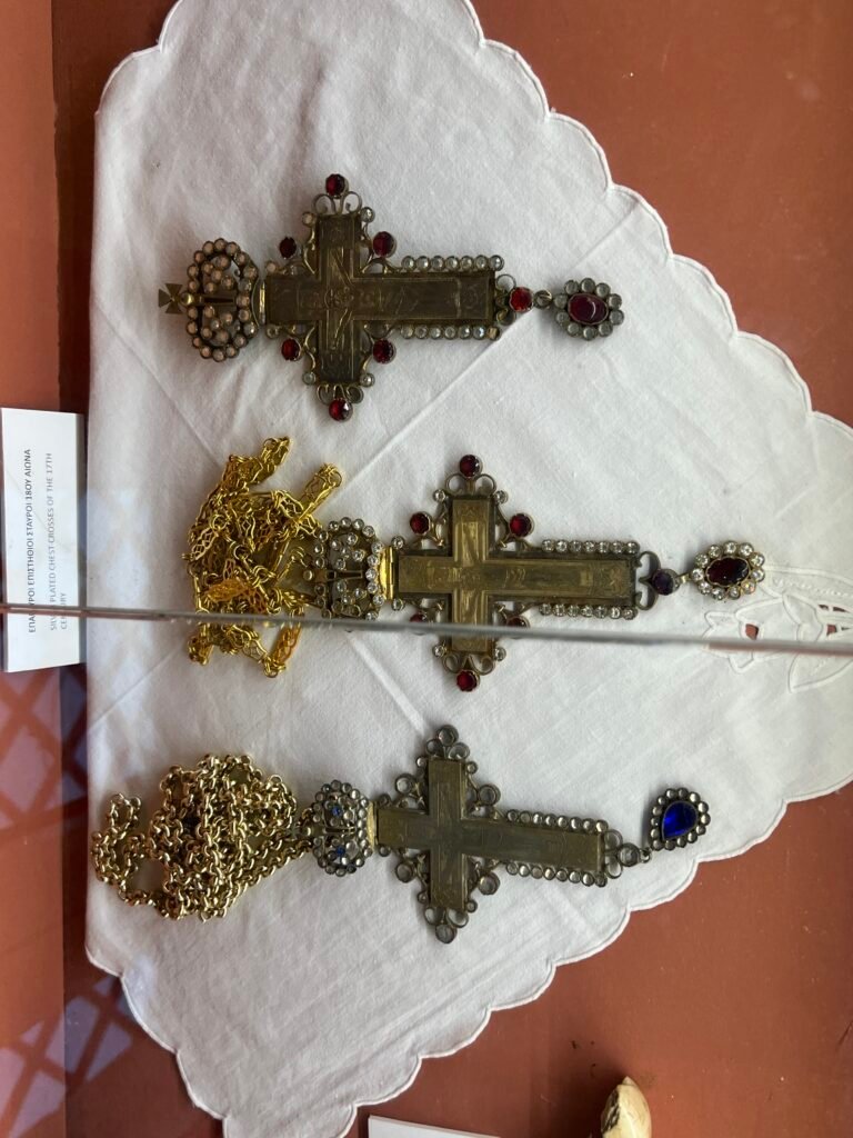 Three ornate religious crosses in a glass display at Paleokastritsa Monastery