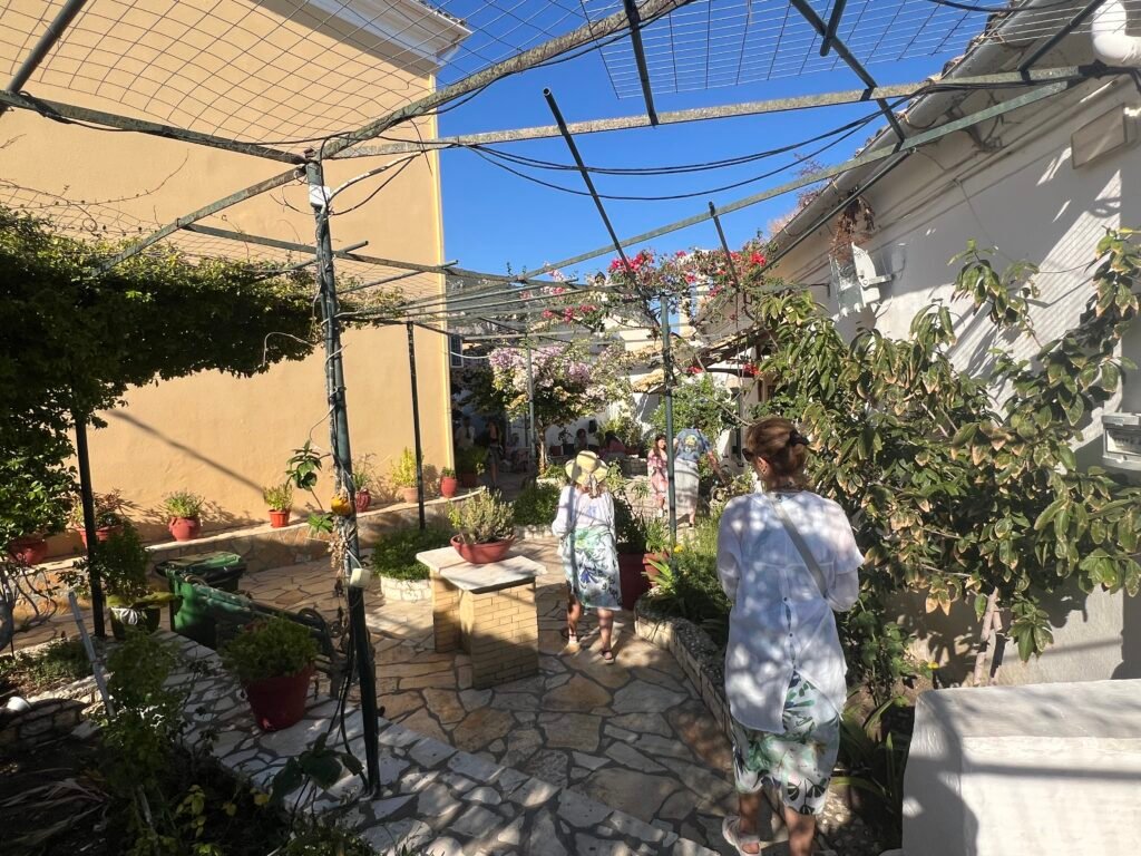 Woman walking through the flower-filled courtyard of Paleokastritsa Monastery